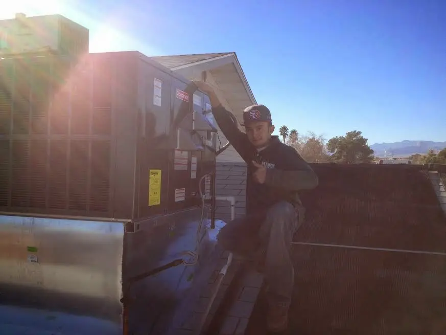 HVAC technician performing AC Tune-Up on a rooftop unit in Gulf Shores